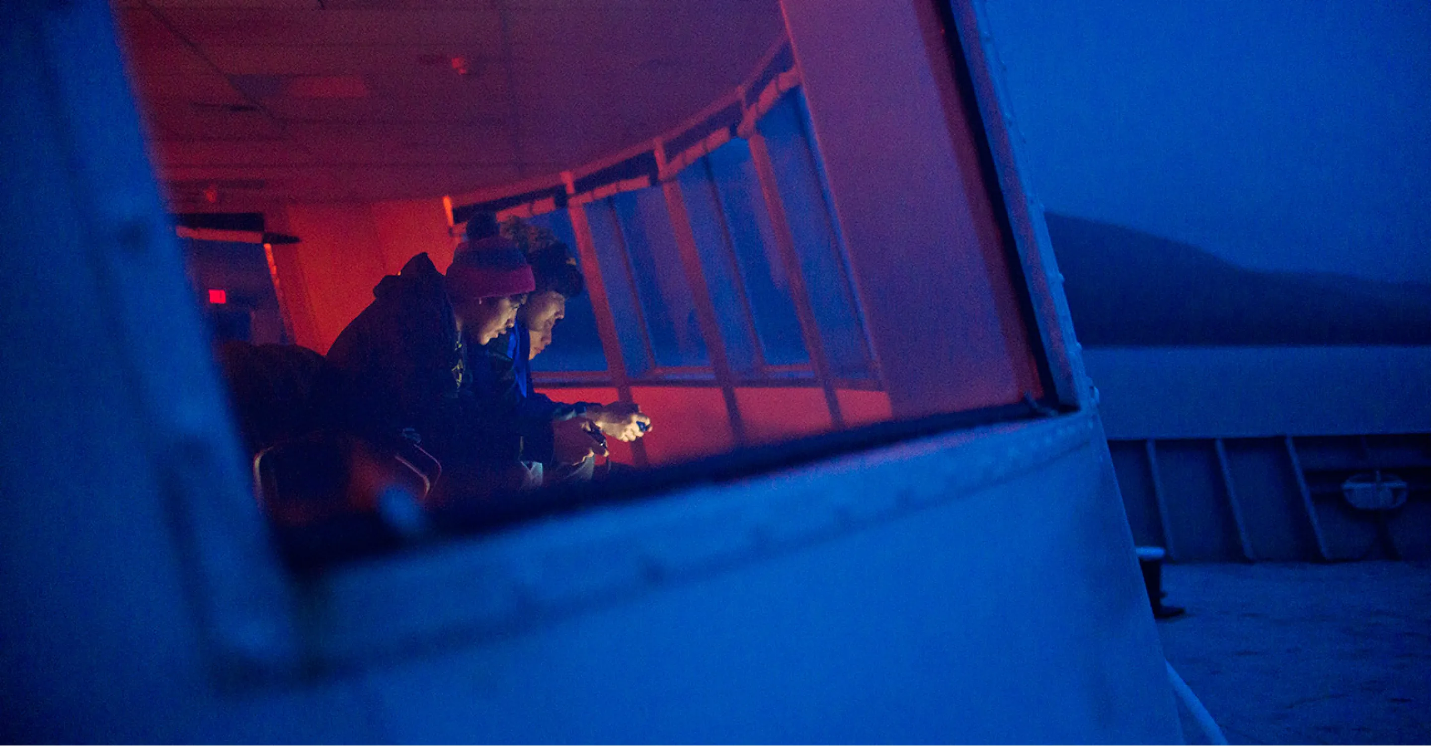 Close shot of two crew members navigating ferry at twilight.